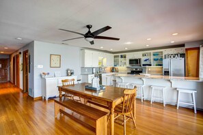 A modern kitchen with white cabinets, a wooden dining table, and a ceiling fan. - Cedar Creek Lakefront Vacation Rental w/ Pool (Gun Barrel City)