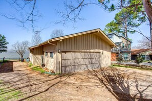A single-story house with a garage, a small porch, and a backyard. - Cedar Creek Lakefront Vacation Rental w/ Pool (Gun Barrel City)