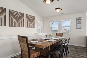 A dining area with a wooden table, chairs, and artwork on the wall.