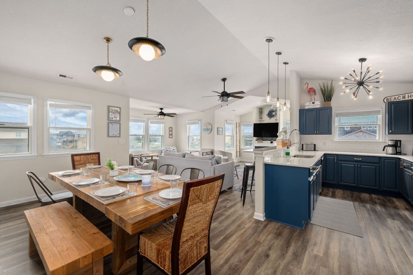 A modern kitchen with a central island, pendant lighting, and a view of the neighborhood.