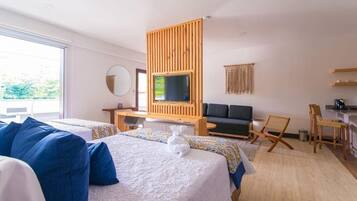 Habitación de hotel con cama, escritorio, televisión y zona de estar.