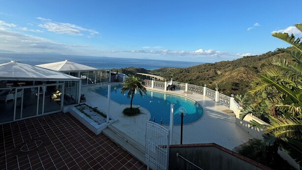 A pool area with a view of the ocean and hills. - Villa Sotto le Stelle for a relaxing holiday with a view of the Aeolian Islands (Orto Liuzzo)