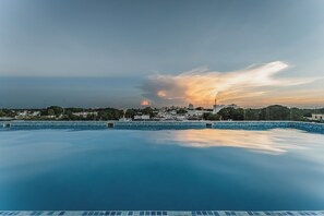 Alberca al aire libre, sombrillas en la alberca y camastros 