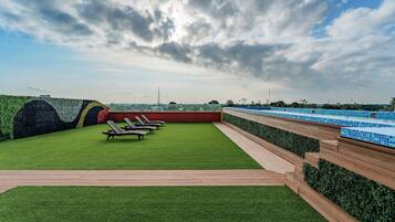 Alberca al aire libre, sombrillas en la alberca y camastros