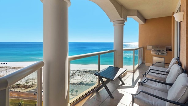 A balcony with a view of the beach, a table, and chairs. - 🏝️Gulf Front-Walk2Beach-Pool-Golf Course-2BR Portofino 5-1708 (Pensacola Beach)
