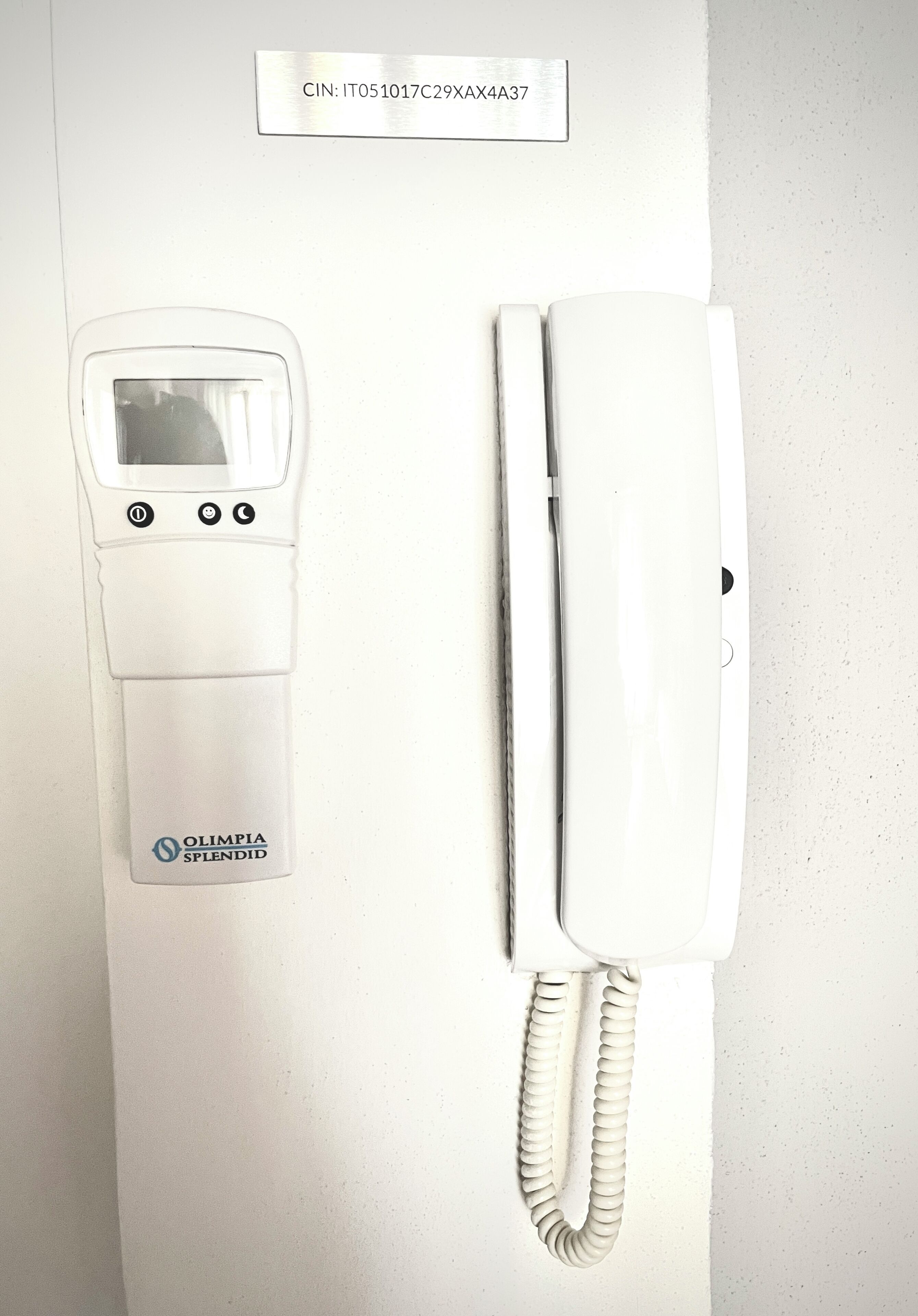 A white telephone with a cord and a digital keypad.