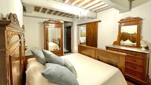 Un dormitorio con una cama grande, muebles de madera y un candelabro.
