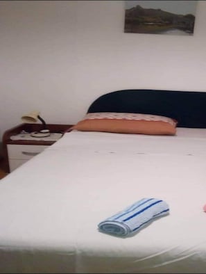 Cozy retreat with a single bed, bedside table, and lamp.