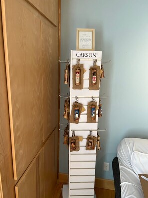 A white, wall-mounted display rack with the brand name 'CARSON' at the top, holding various small, decorative items.