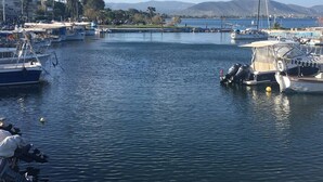 A marina with various boats docked, a bridge in the background, and a hilly landscape. - "Lux 3-bedroom Villa - L&L Refuge" (Nea Makri)