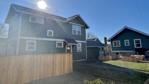 A two-story house with a wooden deck and a small garden area. - Brand New Custom Built Cottage in Downtown w/Pool (Salem)