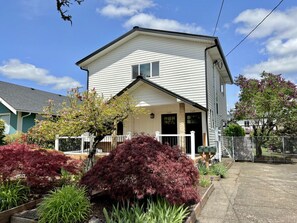 A two-story house with a front porch, a mailbox, and a garage door.