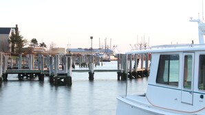 Un port de plaisance avec des bateaux amarrés et une surface d’eau calme.
