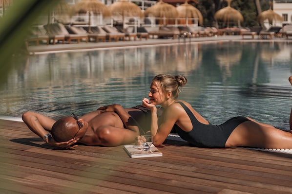 A poolside area with lounge chairs and umbrellas. - Cook's Club Calvia Beach Adults Only +21 (Calvia)