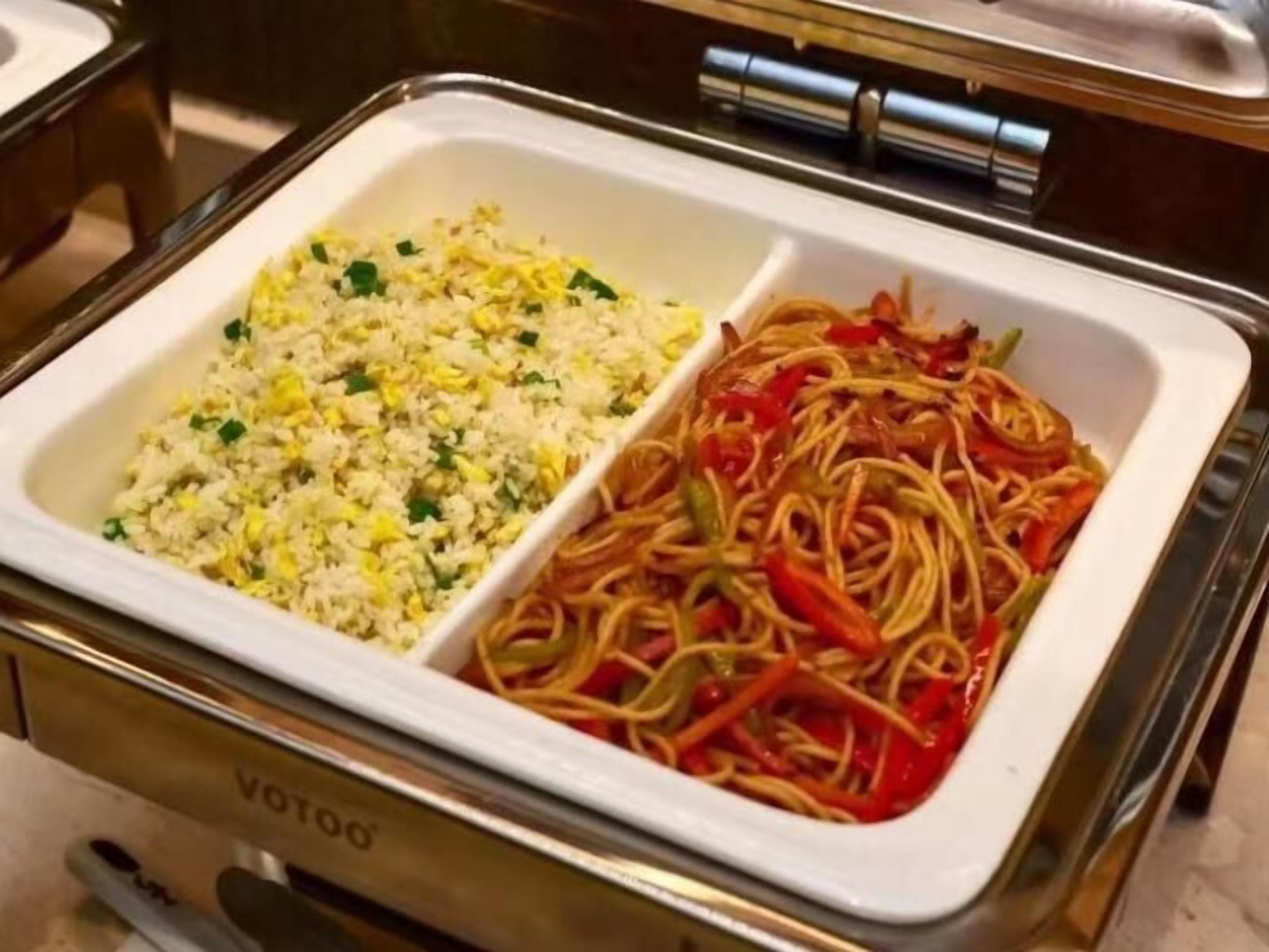 A buffet with two sections: one with fried rice and another with stir-fried noodles and vegetables.