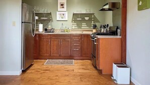 A kitchen with wooden cabinets, a stainless steel refrigerator, and a built-in oven. - Beautiful Canyon View Suite, 1100 sq. ft., private deck, full kitchen (Oakland)