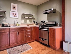 A kitchen with wooden cabinets, a stainless steel stove, and a microwave. - Beautiful Canyon View Suite, 1100 sq. ft., private deck, full kitchen (Oakland)