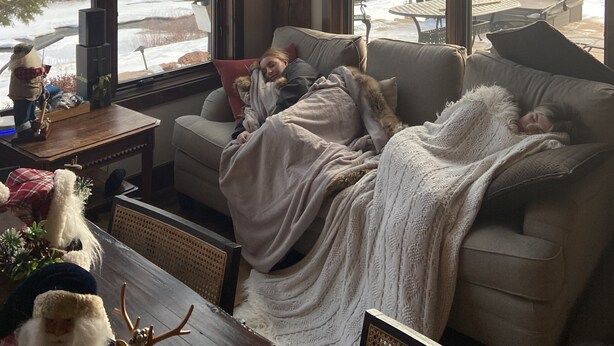 Ein gemütliches Wohnzimmer mit großem Fenster, Kamin und bequemen Sofa.