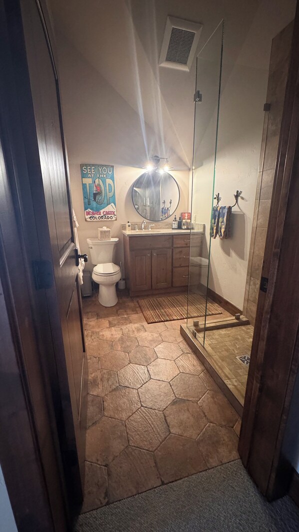 A bathroom with a toilet, sink, and shower area. - Modern Chalet on the River. Hot Tub, Fireplace , Newly furnished Fishing, Hiking (Eagle)