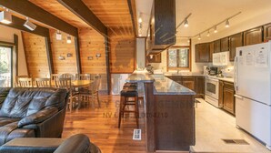 Une cuisine moderne avec des meubles en bois, un îlot central et un coin repas doté de sièges en cuir.