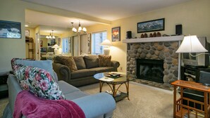 A living room with a fireplace, a sofa, a coffee table, and a television. - Condo at the popular McCloud complex (MC255) (Incline Village)