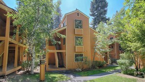 Un bâtiment en bois à deux étages, doté d’un porche couvert et d’un petit escalier menant à un niveau supérieur.