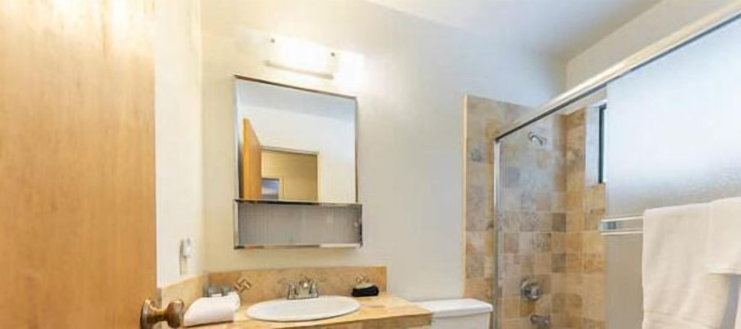A bathroom with a shower, a sink, and a toilet.