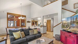 A spacious living room with a large sofa, a coffee table, and a television.