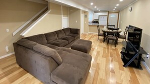 A living room with a sectional sofa, a dining table with chairs, a kitchen area, and a TV stand. - Cozy Condo in Incline (IM62) (Incline Village)