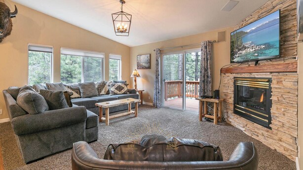 A living room with a fireplace, a sofa, a coffee table, and a television mounted on the wall. - Newly remodel and spacious home (830SO) (Incline Village)