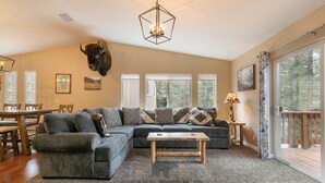 A cozy living room with a sectional sofa, a wooden coffee table, and a bull head mounted on the wall. - Newly remodel and spacious home (830SO) (Incline Village)