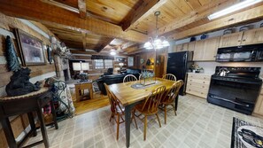A wooden interior with a dining area, kitchen, and living space. - Bruno's Mountain Cave 3 Bedroom Cabin by RedAwning (Sevierville)