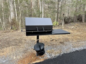 A portable barbecue grill with a flat cooking surface and a pot holder hanging below. - Bruno's Mountain Cave 3 Bedroom Cabin by RedAwning (Sevierville)