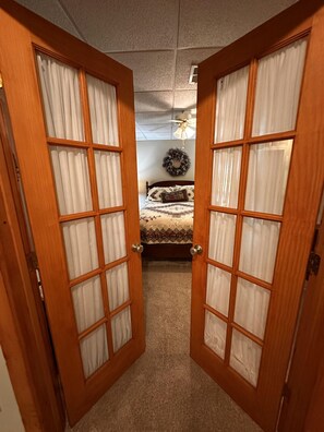 A bedroom with a bed, a ceiling fan, and a wall-mounted wreath. - Bruno's Mountain Cave 3 Bedroom Cabin by RedAwning (Sevierville)