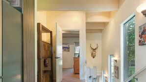 A hallway with a wooden door, a mounted deer head, and a framed poster on the wall. - Lakefront Condo Complex - Beach Access (LA999 35) (Incline Village)