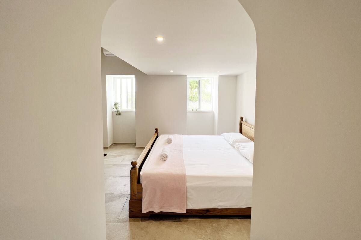 A bedroom with a bed, a window, and a ceiling light.