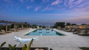Una piscina al aire libre, tumbonas