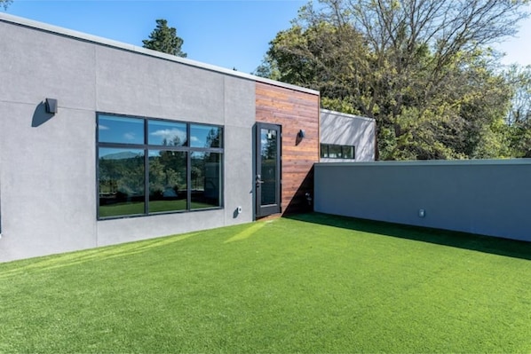 Un bâtiment moderne doté d’un toit plat, de grandes fenêtres et d’une pelouse bien entretenue.