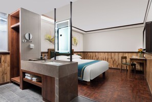A modern hotel room with a wooden vanity, a large bed, a desk, and a view of the outdoors. - Nostalgia Hotel（Taiyuan Shanxi Museum） (Taiyuan)