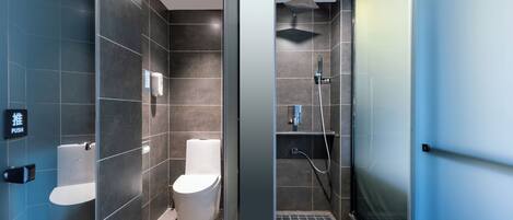 A modern bathroom with a toilet, bidet, and shower area.