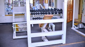 A gym with weightlifting equipment, including dumbbells and benches. - Acactus Hotel kampala  (Kampala)