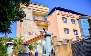 Un hotel con un letrero llamativo que dice "ACTUS HOTEL" y una entrada visible.