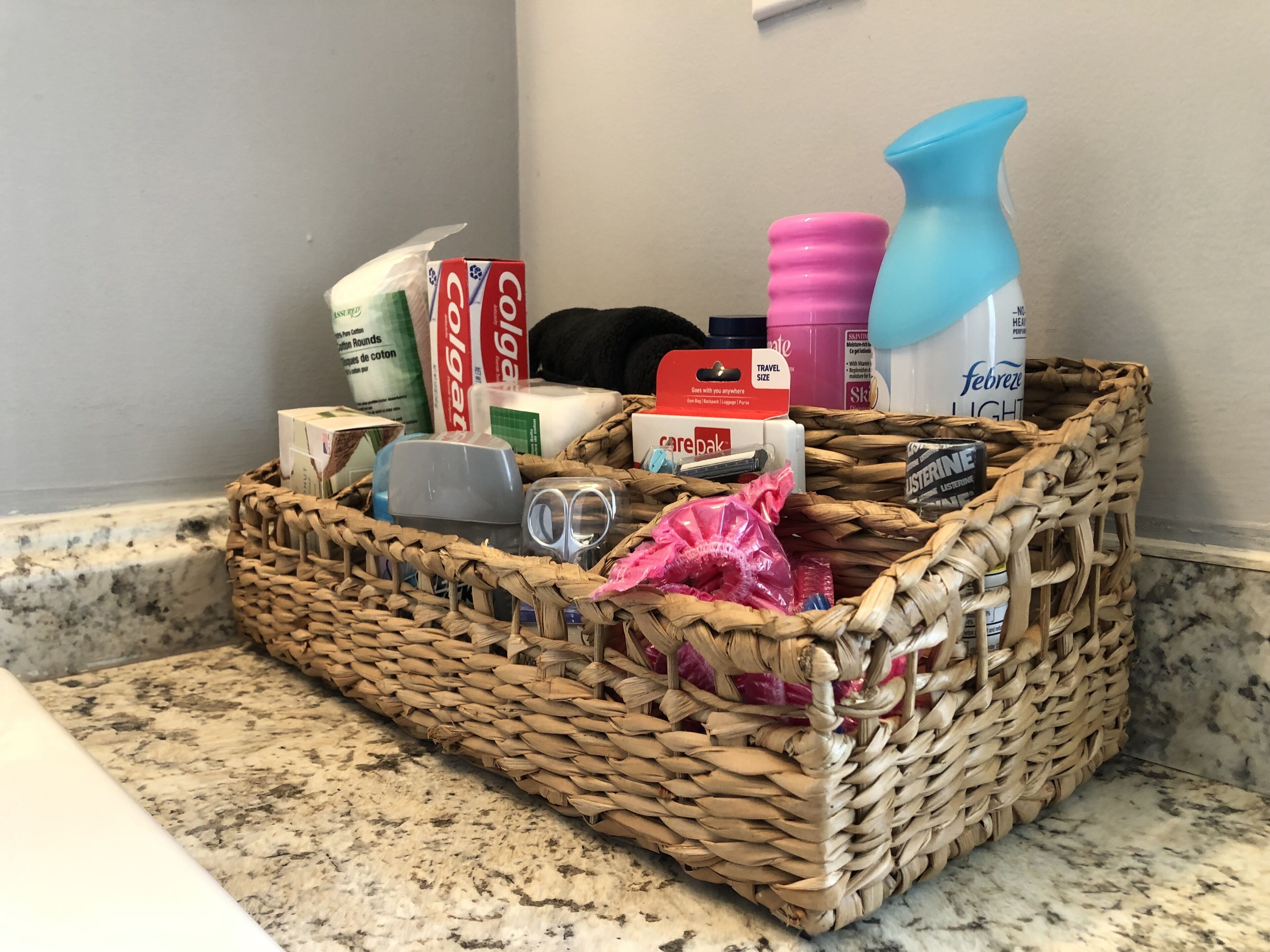 A wicker basket filled with toiletries on a bathroom counter.