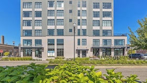 Un immeuble à plusieurs étages doté d’une architecture moderne, caractérisé par de grandes fenêtres et un toit plat.