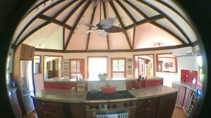 A kitchen with a central island, a ceiling fan, and a view of the living area.