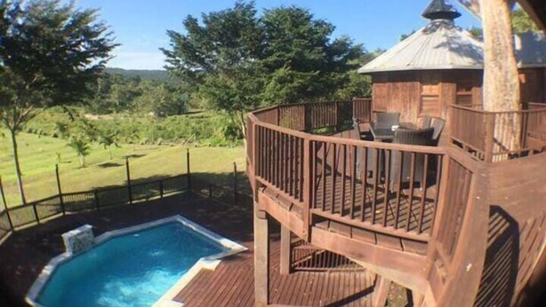 A wooden deck with a hot tub, outdoor furniture, and a gazebo.
