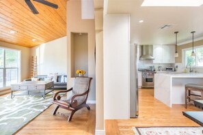 Relax in the open-plan living area with a sofa, chair, and central island kitchen.