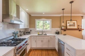 Enjoy cooking in this well-equipped kitchen with a central island, oven, and stainless steel range hood.