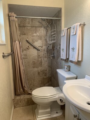 Een douche, handdoeken, zeep, toiletpapier