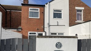 A residential building with a white exterior, a brick section, and a number 31 sign.